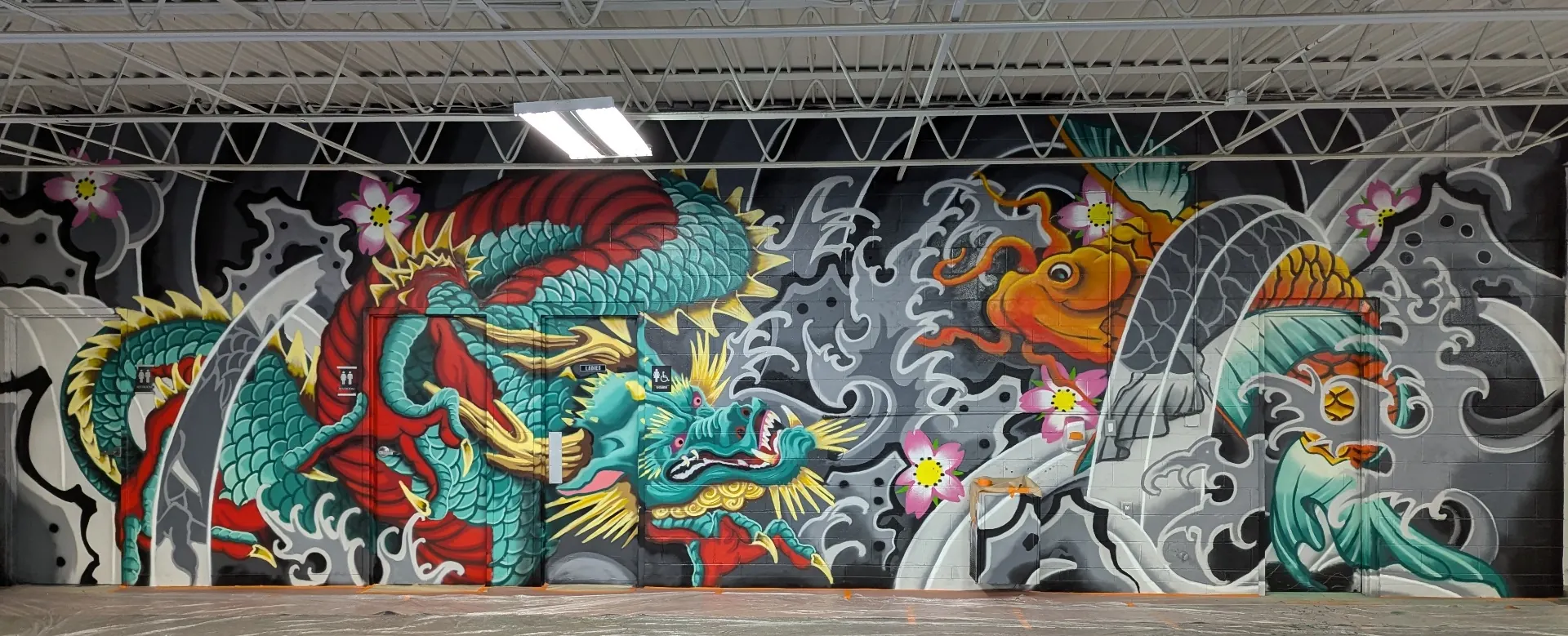 Large-scale dragon and koi mural in an industrial interior hallway